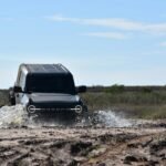Ford Bronco driving through mud.
