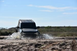 Ford Bronco driving through mud.