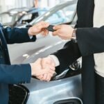 Car dealer handing keys to customer — NC lemon law repurchase vs replacement decision