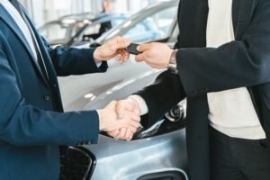 Car dealer handing keys to customer — NC lemon law repurchase vs replacement decision